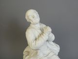 a statue of a man holding a baby in his lap