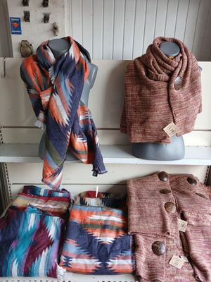 several scarves and scarves are displayed on a shelf in a store