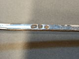 a silver spoon with a silver handle on a table