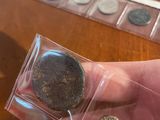 a person holding a coin in their hand on a table