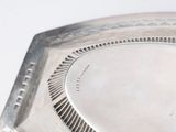 a silver plate with a design on it on a table