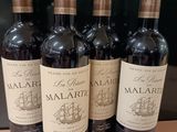 quatre bouteilles de vin sont alignées sur un comptoir
