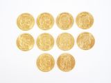 several gold coins are arranged in the shape of a heart on a white surface