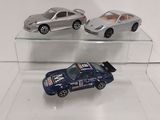 three toy cars that are on display on a clear shelf