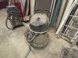une photo d'une pièce où l'on voit un aspirateur et d'autres objets posés par terre
