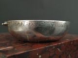 a close up of a silver bowl on top of a wooden table