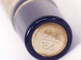 a close up of a bottle of wine on a white surface