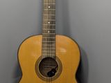 une guitare acoustique posée sur un support dans un coin