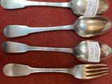 four silver spoons and a fork with a note on them