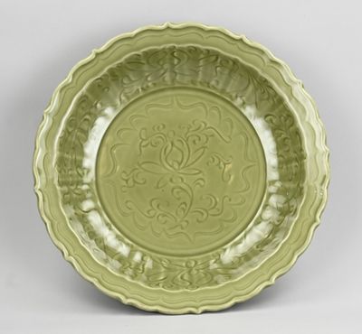 un gros plan d'une assiette verte posée sur une surface blanche