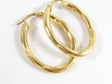 two pairs of gold hoop earrings on a white surface