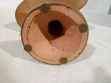 un vase marron posé sur une table blanche