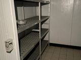 une pièce équipée d'étagères et d'une porte donnant sur une salle de bains