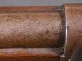 an old gun with a wooden handle on a gray surface