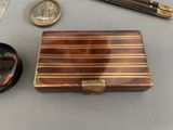 a small wooden box with a pen and other items on a table