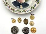 une assiette sur laquelle figure l'image d'un homme en uniforme militaire, entouré de pièces de monnaie