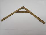 un gros plan d'un triangle en bois posé sur une surface blanche