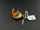 a close up of a gold pocket watch with a tag on it
