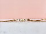 un gros plan sur un bracelet en chaîne en or orné de trois petits diamants