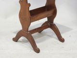 a small wooden table with a magazine rack on it