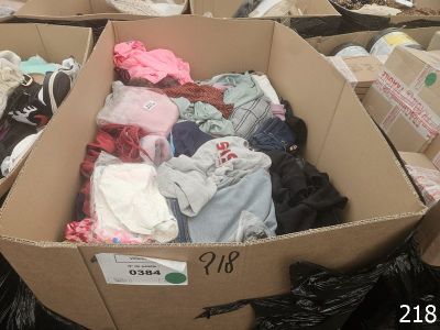 a box full of clothes that is sitting on the floor