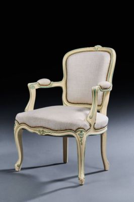 a white chair with a beige upholstered back and arms