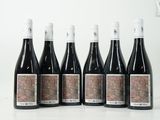 six bouteilles de vin sont alignées sur une table