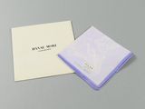 a white and purple handkerchief sitting on top of a white box
