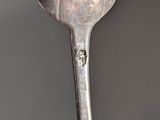 a silver spoon with a silver handle on a table