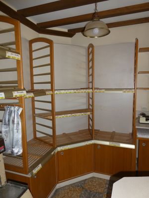 une pièce équipée d'un lit, d'étagères et d'un ventilateur de plafond