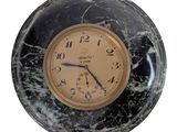 marble clock with black and gold face on a white background