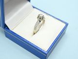 an engagement ring in a blue box on a blue surface