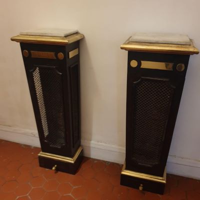 deux socles noirs et dorés dans une pièce