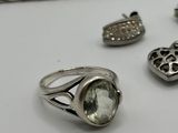 silver jewelry on a white table with a chain and a ring