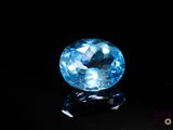 a close up of a blue topazte stone on a black surface