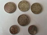six pièces de monnaie britanniques différentes posées sur une surface blanche