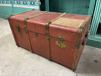 an old suitcase sitting on the floor next to a green cabinet