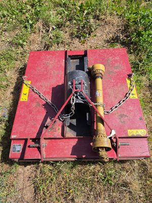 a red box with chains attached to it on the grass