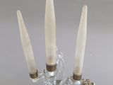un bougeoir en verre contenant trois bougies