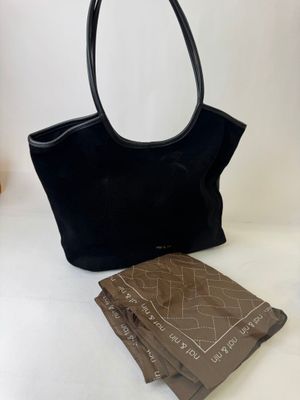 a black purse and a book sitting on a table