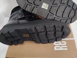 pair of black leather boots on a box on a white surface