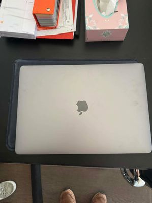 une personne debout devant un ordinateur portable posé sur une table