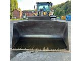 the back end of a black bulldozer sitting in a parking lot