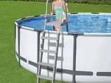une femme assise sur une échelle près d'une piscine