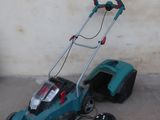 a lawn mower that is sitting on the ground next to a wall