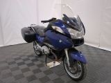 une moto bleue garée sur un sol à carreaux noirs et blancs