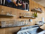 a bar with a bunch of wine glasses on the shelves