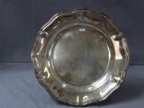assiette en argent avec un bord festonné sur fond gris