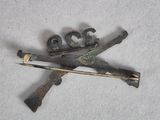 a small piece of metal with two crossed swords on it