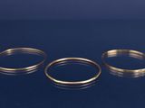 trois anneaux dorés posés sur une surface bleue